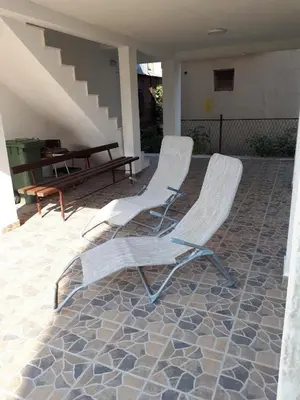 two white chairs sitting on a patio with a table at Strandhaus Adria in Ulcinj