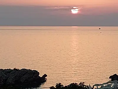 a sunset over the ocean with the sun in the sky at Queen Apartments & Rooms in Dobra Voda