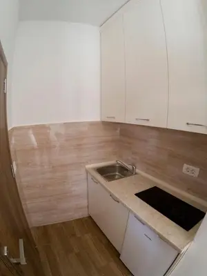 a kitchen with white cabinets and a sink at Queen Apartments & Rooms in Dobra Voda