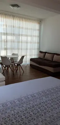 a living room with a couch and a table and chairs at Queen Apartments & Rooms in Dobra Voda
