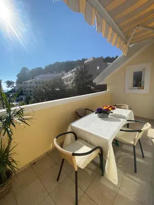 a patio with a table and chairs on a balcony at Miomir Perazic Apartments in Petrovac na Moru