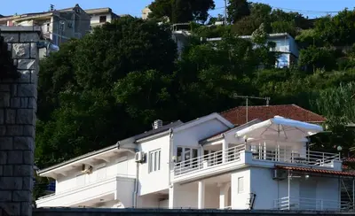a white house with a balcony on a hill at Villa Guci in Ulcinj