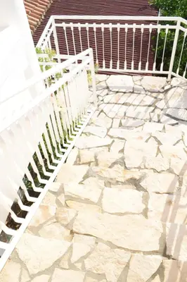 a white fence next to a stone patio at Villa Guci in Ulcinj