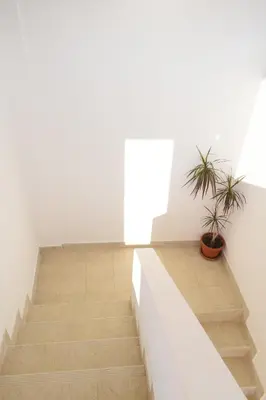 a staircase in a white room with a potted plant at Villa Guci in Ulcinj