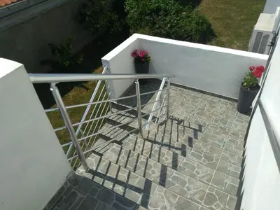 a stairway with a railing and two potted plants at Apartment Djordje Budva-Jaz in Kukaljevina