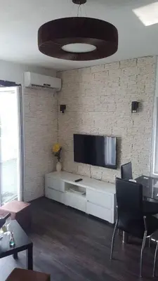 a living room with a flat screen tv on a brick wall at Apartment Djordje Budva-Jaz in Kukaljevina
