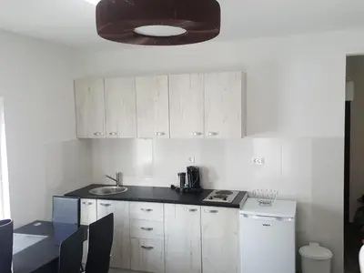 a kitchen with white cabinets and a black counter top at Apartment Djordje Budva-Jaz in Kukaljevina