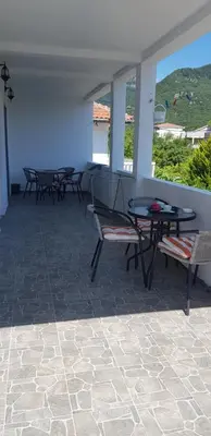 a patio with chairs and a table and a table and benches at Apartment Djordje Budva-Jaz in Kukaljevina