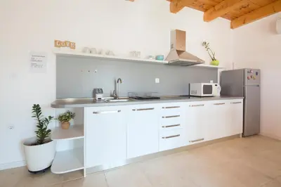 a kitchen with white cabinets and a stainless steel refrigerator at Apartments Al Parma in Budva