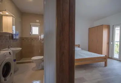 a bathroom with a bed and a toilet and a sink at 3rooms,11 people in Bar