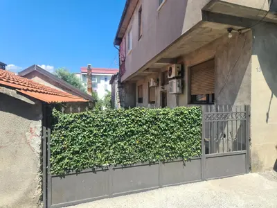 a ivy covered fence in front of a building at Ori in Podgorica