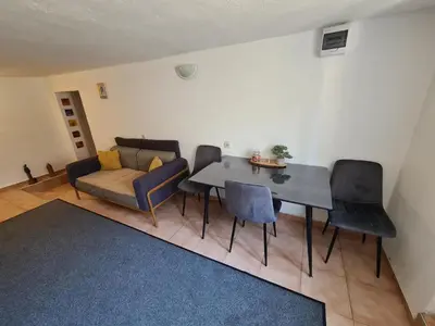a living room with a table and chairs and a couch at Ori in Podgorica