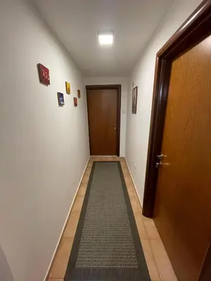 an empty hallway with a door and a carpet at Ori in Podgorica