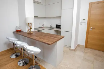 a kitchen with a counter and two stools in it at Apartment with sea view in Rafailovici