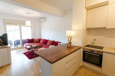 a kitchen and living room with a red couch at Apartment with sea view in Rafailovici