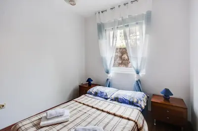 a small bedroom with a bed and a window at Apartment Lavender of Budva in Budva