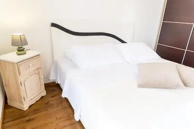 a bedroom with two beds and a night stand with a lamp at Lagoon Apartments in Budva