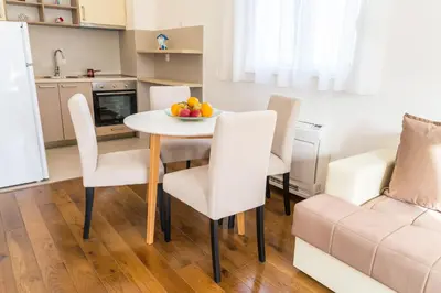 a kitchen and dining room with a table and chairs at Lagoon Apartments in Budva