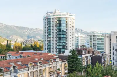 a group of buildings in a city with mountains at Lagoon Apartments in Budva