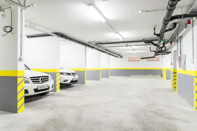 two cars parked in a garage with yellow and white walls at Lagoon Apartments in Budva