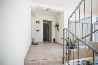 a staircase in a home with white walls and tile floors at Guest House Djonovic in Petrovac na Moru