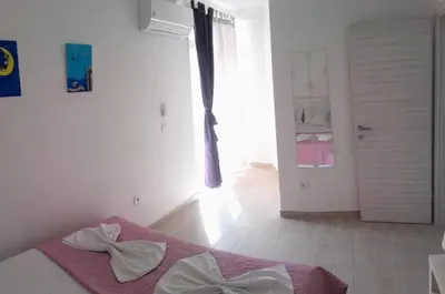 a bedroom with a bed in a room with a door at Guest House Djonovic in Petrovac na Moru