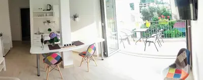 a room with a desk and chairs and a balcony at Guest House Djonovic in Petrovac na Moru