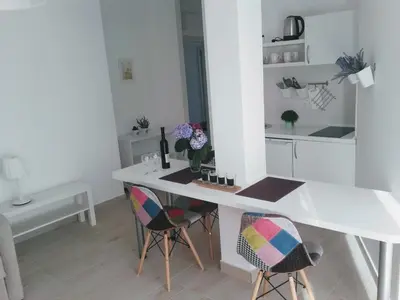 a kitchen with a white table and two chairs at Guest House Djonovic in Petrovac na Moru