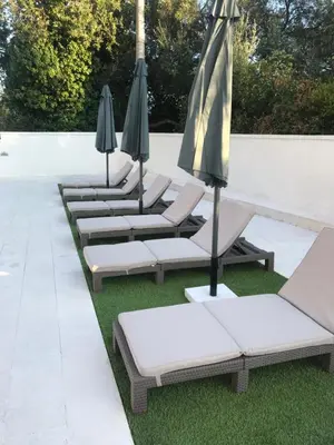 a row of lounge chairs with umbrellas on the grass at Lux Apartment MMS1 in Krimovice