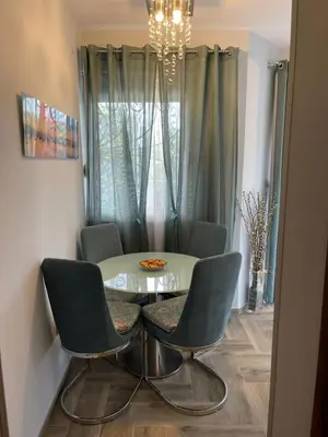a dining room table with two chairs and a chandelier at Lux Apartment MMS1 in Krimovice