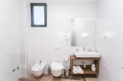 a white bathroom with a sink and a toilet at Villa Delux in Ulcinj