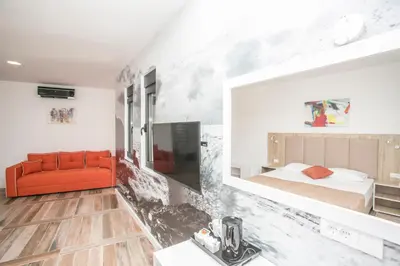 a bedroom with a bed and a red couch at Villa Delux in Ulcinj