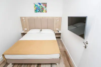 a small bedroom with a bed and a tv at Villa Delux in Ulcinj