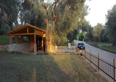 a small building with a car parked next to a road at Olive Paradise in Ulcinj