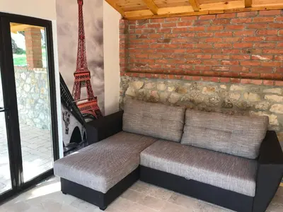 a bench sitting next to a brick wall with the eiffel tower at Olive Paradise in Ulcinj