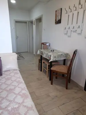 a dining room with a table and chairs and a floor at Apartman SB in Ulcinj