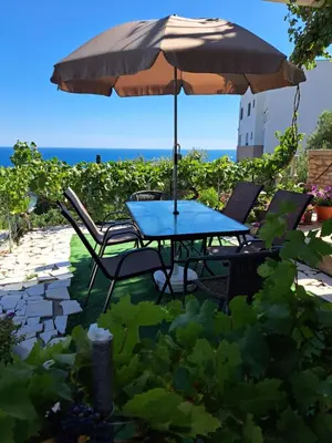 a table and chairs under an umbrella on a patio at Apartman SB in Ulcinj