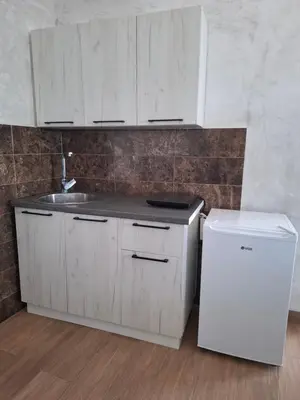 a kitchen with white cabinets and a sink and a refrigerator at Diamond by EXCLUSIVE Collection Sea view apartments in Dobra Voda