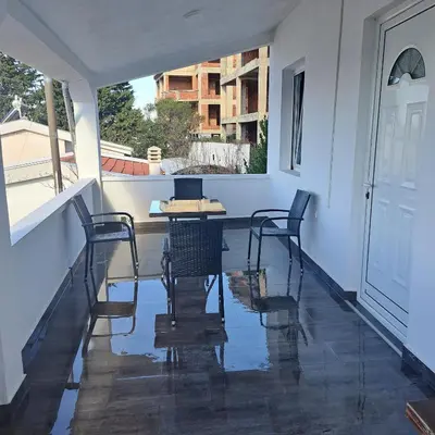 a porch with chairs and a table and a window at Diamond by EXCLUSIVE Collection Sea view apartments in Dobra Voda