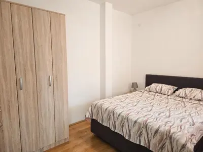 a bedroom with a bed and a wooden cabinet at Village experience - Skadar lake in Virpazar