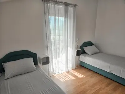 a bedroom with two beds and a large window at Village experience - Skadar lake in Virpazar