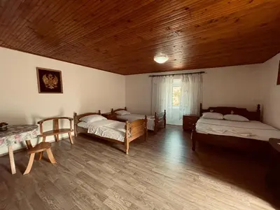 a room with three beds and a wooden ceiling at Rustic village in Rijeka Crnojevića