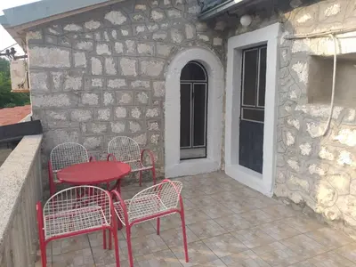 a red table and chairs on a patio at Rustic village in Rijeka Crnojevića