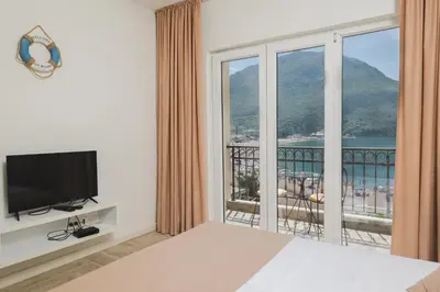 a bedroom with a large window with a view of the ocean at Villas Promis in Čanj