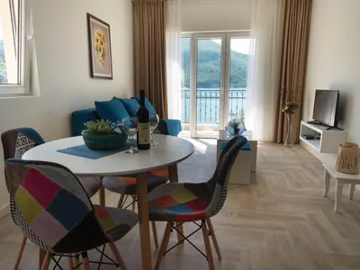 a living room with a table and chairs and a couch at Villas Promis in Čanj