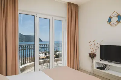 a bedroom with a large window with a view of the ocean at Villas Promis in Čanj