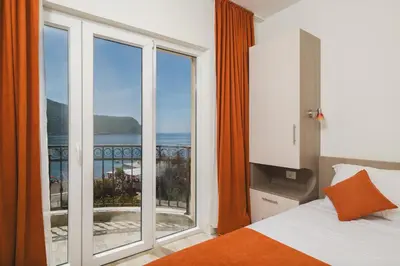 a bedroom with a large window with a view of the ocean at Villas Promis in Čanj