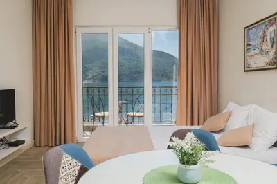 a living room with a table and a large window at Villas Promis in Čanj