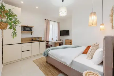a bedroom with a large bed and a kitchen at VerDi in Kotor