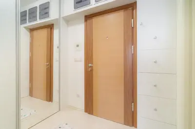 a hallway with two wooden doors and white cabinets at HarMony apartment in Budva